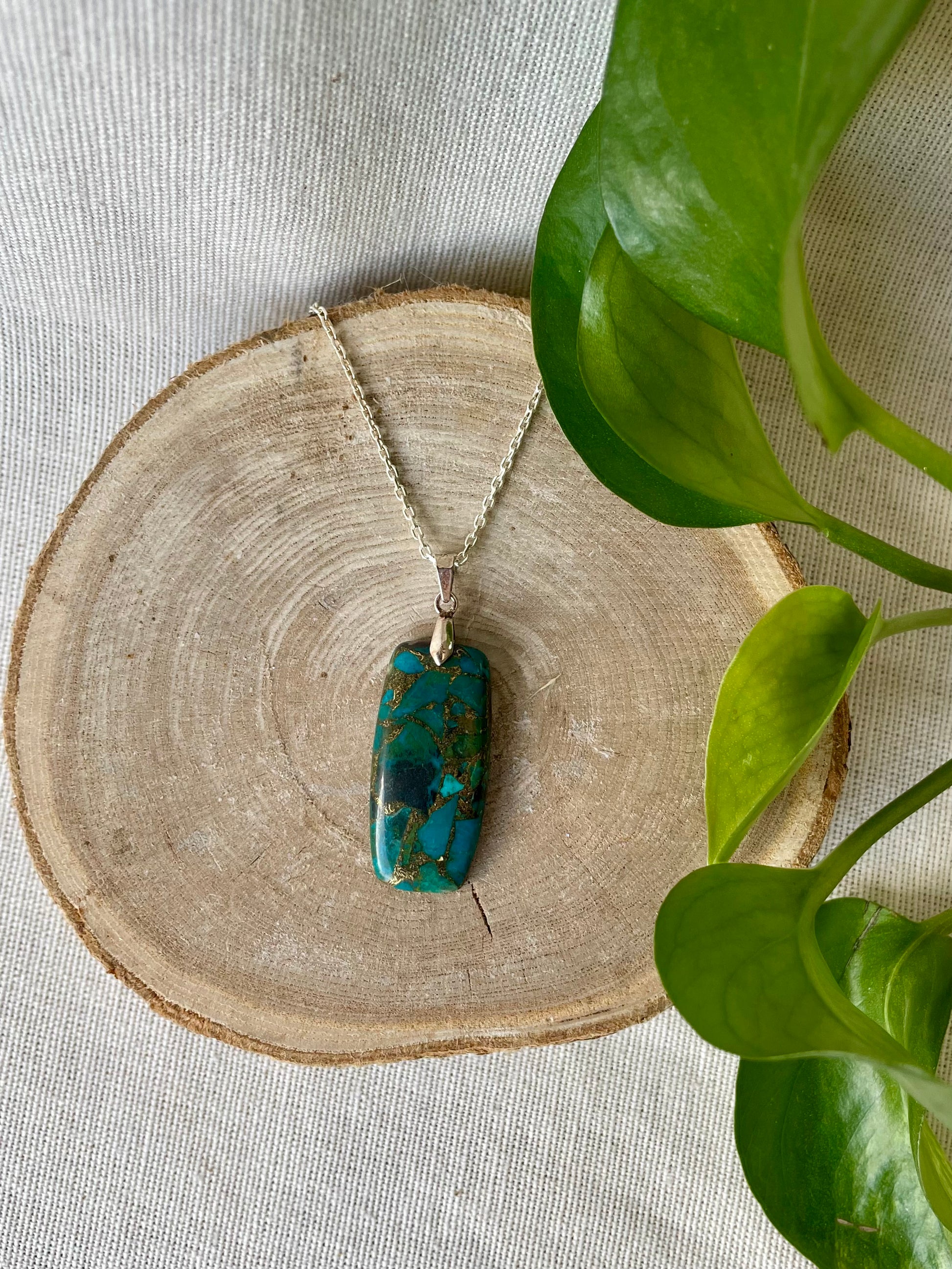 « Pendentif en chrysocolle naturelle avec inclusions de cuivre, pierre apaisante et harmonisante, parfaite pour équilibrer les énergies et stimuler la créativité.